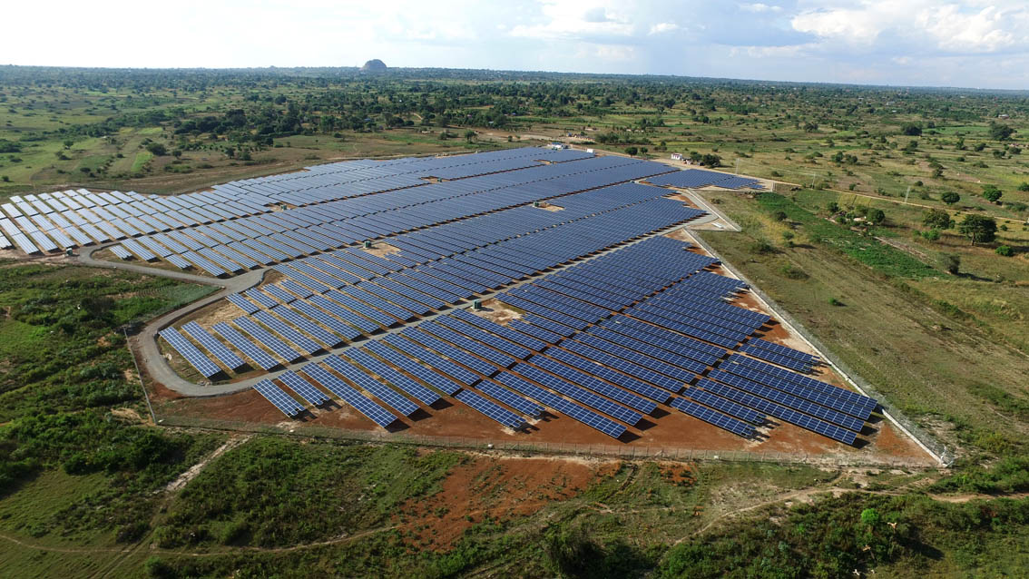 Aerial view of a utility-scale solar power plant integrated into a working landscape